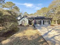 Charming one-story home with a gray exterior, landscaped lawn, and a long driveway at 786 Savannah Dr., Pawleys Island, SC 29585