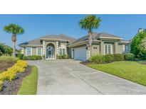 Charming home featuring lush landscaping, a spacious driveway, and inviting curb appeal at 2000 Hideaway Point, Myrtle Beach, SC 29579