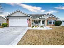 Brick ranch home with a white garage door and landscaped yard at 2102 Hawksmoor Dr., Conway, SC 29526