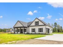 White farmhouse exterior with black accents, gray roof, and a spacious yard at 224 William Nobles Rd., Aynor, SC 29511
