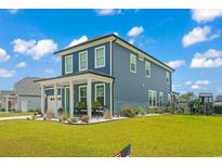 Two-story blue house with white trim, landscaping, and a teal door at 375 Bumble Circle, Murrells Inlet, SC 29576