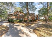 Brick house with a large front yard, long driveway and mature trees at 4351 Lakeside Dr., Little River, SC 29566
