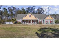 Charming single-story home featuring a large front yard, red accents, and a welcoming front porch at 640 Fox Hollow Rd., Murrells Inlet, SC 29576