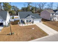 Aerial view of a charming house with a gray roof and white siding, a two-car garage and well-manicured lawn at 123 Grissett Lake Dr., Conway, SC 29526