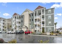 Exterior of a three-story building with multiple units, ample parking, and a well-maintained appearance at 157 Ella Kinley Circle # 303, Myrtle Beach, SC 29588
