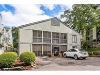 Exterior view of a light grey multi-unit building with a screened porch and parking at 309 74Th Ave. N # 18, Myrtle Beach, SC 29572