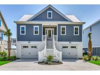 Inviting coastal home with double garage, white trim, and covered entry staircase at 42 Mud Minnow Dr., Pawleys Island, SC 29585