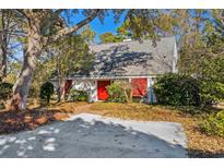 Charming house with red door, surrounded by lush landscaping and a spacious driveway at 560 Aspen Loop, Pawleys Island, SC 29585