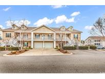 Tan three-unit building, two-story, with white trim, staircases, and attached garages at 834 Sail Ln. # 202, Murrells Inlet, SC 29576