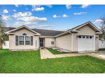 Beige house with a two-car garage and well-maintained lawn at 9650 Bradford Ln., Murrells Inlet, SC 29576