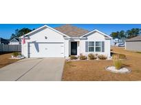 White house with two-car garage and landscaped lawn at 124 Golden Bear Circle, Longs, SC 29568