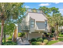 Elevated home with spacious deck, water views, and stairs leading to the entrance at 25 Frigate Ct., Pawleys Island, SC 29585
