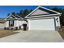 Charming one-story home with a two-car garage and well-manicured lawn at 328 Blue Rock Dr., Longs, SC 29568