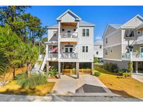 Two-story home with white siding, large windows, and a two-car garage at 34 Lazy Hammock Trail, Pawleys Island, SC 29585