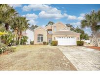 Two-story brick house with a white garage door and landscaped lawn at 508 5Th Ave. S, North Myrtle Beach, SC 29582