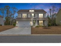 Two-story house with gray siding, white garage door, and landscaping at 104 Grace Bay Ct., Pawleys Island, SC 29585