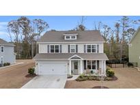 Charming two-story home with a well-maintained front yard and attached garage at 104 Grace Bay Ct., Pawleys Island, SC 29585