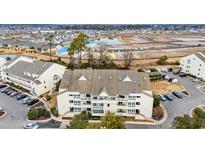Aerial view of a condo building with ample parking and a tennis court nearby at 1100 Possum Trot Rd. # E-238, North Myrtle Beach, SC 29582
