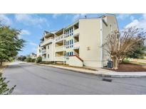 Multi-level condo building featuring private balconies and traditional architecture with light yellow siding at 1100 Possum Trot Rd. # E-238, North Myrtle Beach, SC 29582