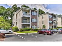 Two-story condo building with ample parking and landscaping at 1302 River Oaks Dr. # 4-F, Myrtle Beach, SC 29579