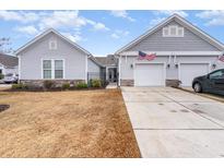 Charming home featuring gray siding, stone accents, a two-car garage, and well-manicured landscaping at 1594 Palmina Loop # B, Myrtle Beach, SC 29588