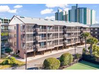 Exterior view of a three-story building with balconies and tennis courts at 207 N Ocean Blvd. # 146, North Myrtle Beach, SC 29582