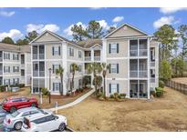 Inviting condo building with multiple stories, manicured landscaping, and ample parking at 242 Sun Colony Blvd. # 303, Longs, SC 29568