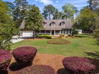 Charming home featuring a well-manicured front yard and a welcoming front porch at 40 Capt Anthony White Ln., Georgetown, SC 29440