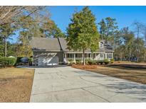 Charming home with a well-manicured lawn and a long driveway leading to an attached two-car garage at 40 Capt Anthony White Ln., Georgetown, SC 29440