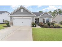 Charming single-story home features a well-manicured lawn and attached two-car garage at 688 Tattlesbury Dr., Conway, SC 29526