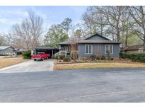 Gray house with red door, carport, and landscaping at 825 Colony Dr., Murrells Inlet, SC 29576