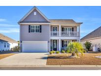 Two-story house with gray siding, white garage door, and landscaping at 1208 Maxwell Dr., Little River, SC 29566