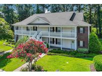 Two-story building with brick and white siding, balconies, and landscaping at 1262 River Oaks Dr. # 13B, Myrtle Beach, SC 29579