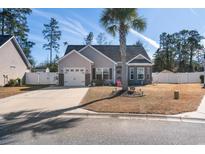 Charming single-story home with a well-manicured front yard, palm tree, and a paved driveway leading to a two-car garage at 160 Maggie Way, Myrtle Beach, SC 29588