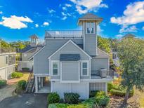 Gray two-story house with a rooftop deck and attached garage at 1609 Harbor Dr., North Myrtle Beach, SC 29582