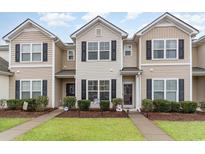 Tan and beige townhome with black shutters, landscaping, and walkway at 173 Olde Towne Way # 3, Myrtle Beach, SC 29588