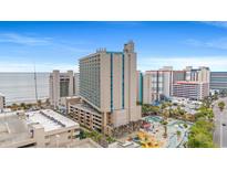 Aerial view of beachfront high-rise building with pool and playground at 201 74Th Ave. N # 1405, Myrtle Beach, SC 29572