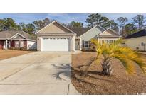 House exterior featuring a two-car garage and a well-maintained lawn at 202 Sugar Mill Loop, Myrtle Beach, SC 29588