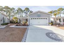 Gray house with white garage door and landscaped yard at 3040 Thoroughfare Dr., Conway, SC 29526