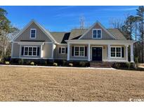 Two-story house with beige siding, navy blue shutters, and a front porch at 3220 Highway 19, Conway, SC 29526