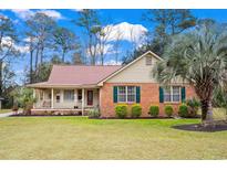 Brick ranch house with green shutters, palm tree, and spacious lawn at 40 Governor Boone Ln., Georgetown, SC 29440