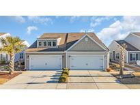 Tan two-story home with two-car garage and landscaped yard at 4379 Livorn Loop # 4379, Myrtle Beach, SC 29579