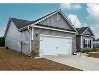 Attached two-car garage with a white door and brick accents matching the gray vinyl siding of the single Gathering home at 456 Hayloft Circle, Conway, SC 29526