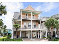Charming raised beach home featuring double balconies, ground floor parking, and beachside access at 504 21St Ave. N, North Myrtle Beach, SC 29582