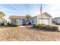 Beige house with two car garage and manicured lawn at 567 Woodholme Dr., Conway, SC 29526