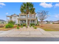 Charming two-story home featuring a welcoming front porch and beautifully landscaped yard with palm trees at 836 Crystal Water Way, Myrtle Beach, SC 29579