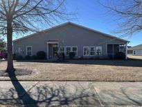 Rear view of house, showcasing a screened porch and well-maintained lawn at 900 British Ln. # 1187, Myrtle Beach, SC 29579