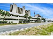 Oceanfront building with parking and tropical landscaping at 1012 N Waccamaw Dr. # 902, Murrells Inlet, SC 29576