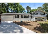 Charming updated two-story home featuring a grey and white painted brick facade, well-kept lawn, and attached garage at 106 Governor Boone Ln., Georgetown, SC 29440