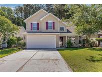 Two-story house with beige siding, attached garage, and manicured lawn at 1247 Brighton Ave., Myrtle Beach, SC 29588